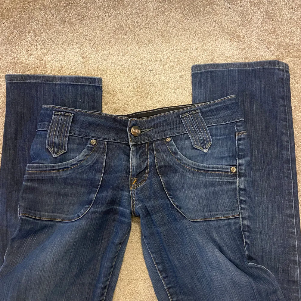 Lågmidjade Lee jeans i en mörk tvätt med coola fickor där bak, för små för mig tyvärr. Jeans & Byxor.