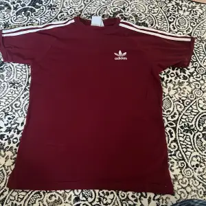Adidas T-shirt i en mörkare röd färg. Fint skick! Strl S