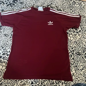 Adidas T-shirt - Adidas T-shirt i en mörkare röd färg. Fint skick! Strl S