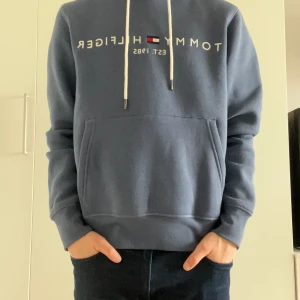 Helt ny Tommy hillfiger hoodie - Säljer denna hoodie från Tommy hillfiger i färgen blå. Hoodien är helt oanvänd där till och med prislappen är kvar och inga skavanker eller liknande förekommer på produkten. Storleken är S och sitter som S.
