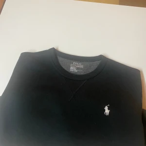 Ralph lauren sweatshirt - Säljer en svart Ralph lauren sweatshirt knappt använd i princip (nyskick) som bara samlar damm i garderoben,  Tröjan är fräsch och nytvättad. Nyköpt hos care of carl, storlek: S