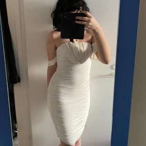 Femme Luxe-klänning - Superfin draperad off the shoulder-klänning. Köpt på vinted, säljer då den tyvärr är för liten för mig. Slit på baksidan, se bild. Kan finnas några mindre fläckar i stil med den på sista bilden, men inget som förstör helheten :)