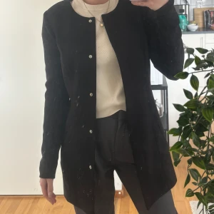 Svart kappa - Svart kappa i midilängd. Jackan är använd men fortfarande fint skick och inga synliga märken/skavanker. 