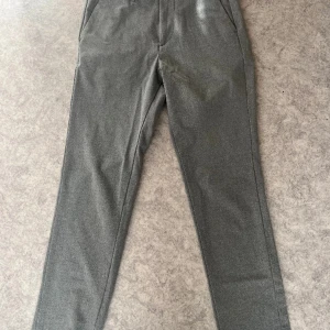 Kostymbyxor tonåring - Snygga och sköna grå kostymbyxor från Jack&Jones. Sparsamt använda, mjuka i tyget. Modell Slim/Marco. Storlek 27/30(midja/benlängd)