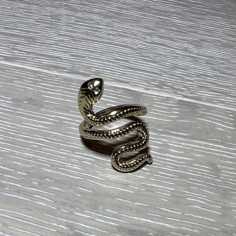 Säljer denna ormformade ring som är guldfärgad! Den är ganska stor på mig men passar på min tumme! Väldigt fin och knappt använd!. Accessoarer.