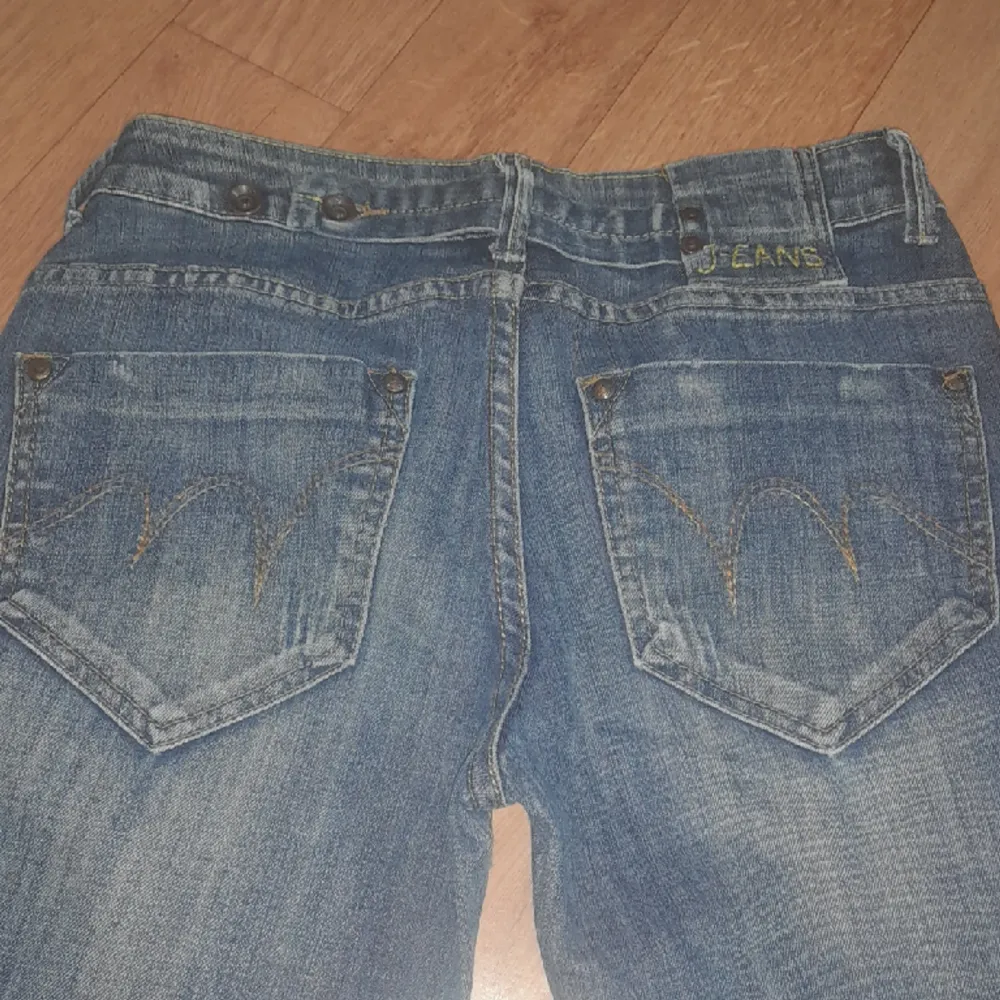 Jätte jätte snygga blåa lågmidjade blåa jeans med coola tryck på fickorna och olika fina detaljer framme vid låren storlek S/M säljer för 300kr+ 50 kr frakr . Jeans & Byxor.