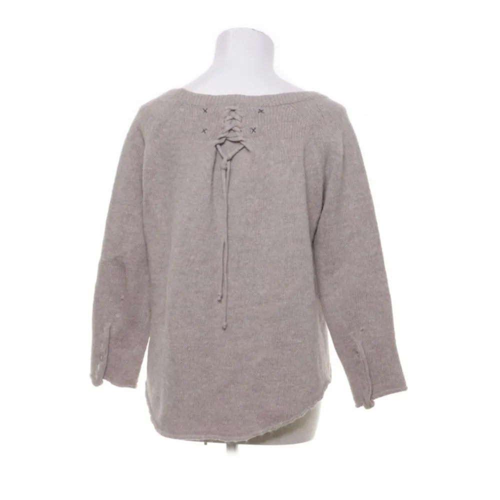 En jättefin beige stickad tröja med en fin detalj på baksidan och knappar på armarna😊 säljer pga kommer ej till användning😔. Tröjor & Koftor.