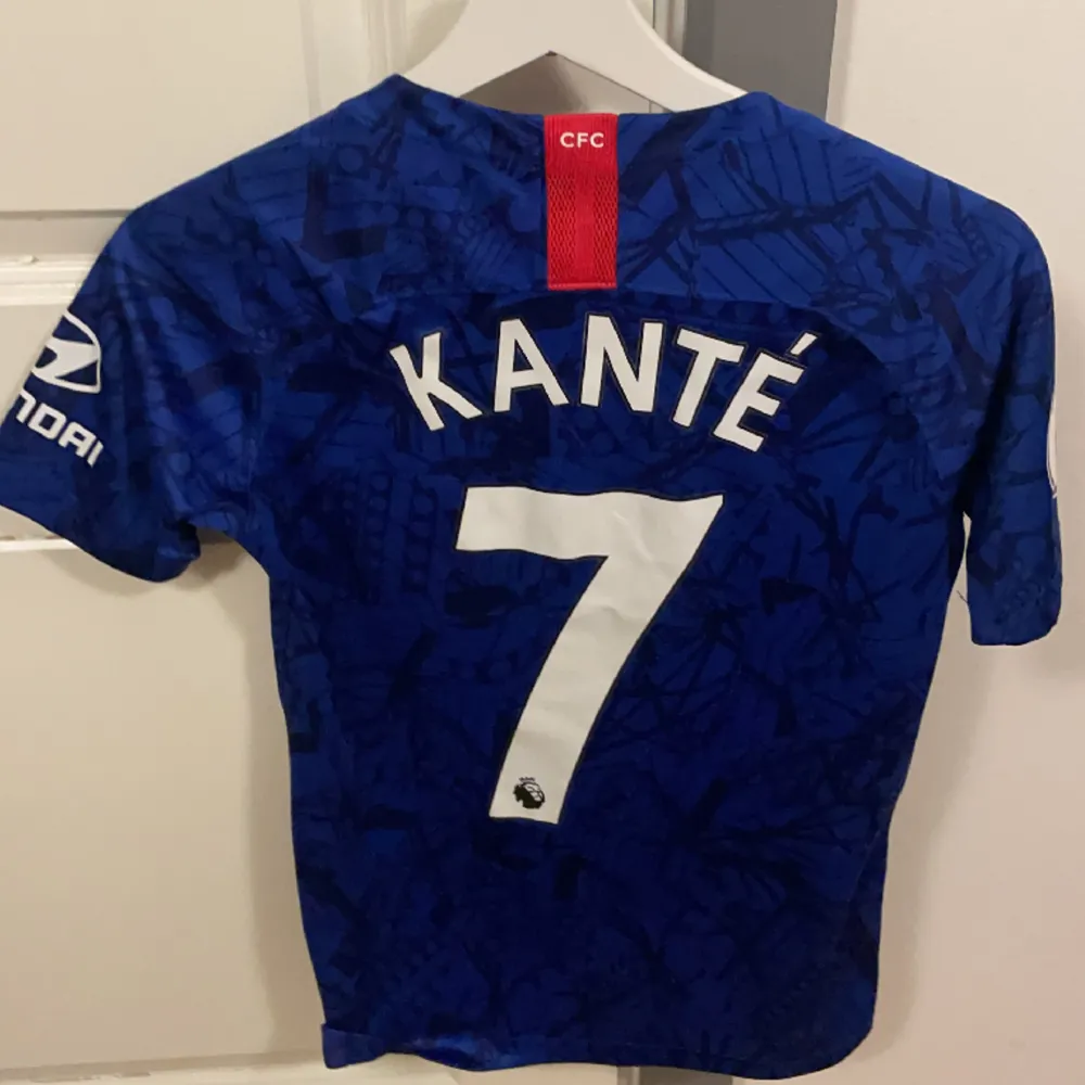 Chelsea FC Tröja med tryck ”KANTÉ” på ryggen I fint skick från säsong 2019/20 Äkta vara - köpt från unisport Storlek : L i barnstorlek men kan även passa XS. T-shirts.