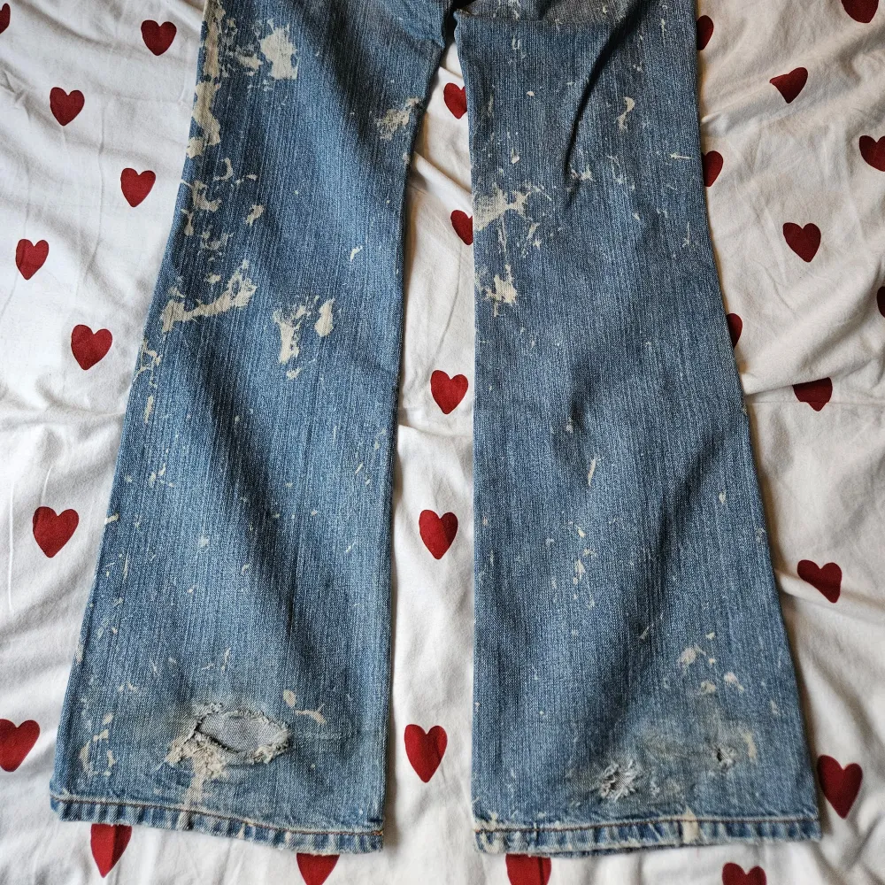 Lågmidjade jeans med blekningar ifrån Hippie. Passar XS/S och någon som är 170 eller över. Har en slitning på låret under 