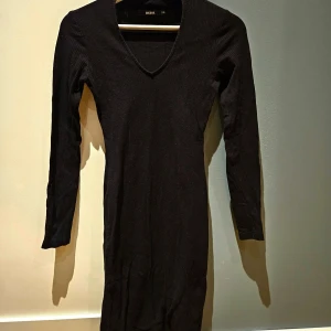 Svart klänning - Svart klänning med v-ringning i ribbat material från bikbok. Gott skick. 