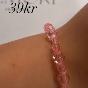 Rosa armband med pärlor - Ett vackert rosa armband med genomskinliga pärlor. Armbandet är elastiskt och passar de flesta handleder.