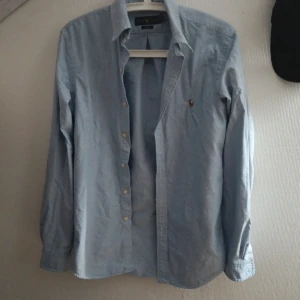 Ralph Lauren skjorta - Riktigt fet slim fit ljusblå skjorta i märket Ralph Lauren, storlek M ✅  Skick 8/10, skada från brodering på bröstet syns på fjärde bild  Mått: B, 42 cm / L, 70 cm  Pris går att diskutera 🤝✅