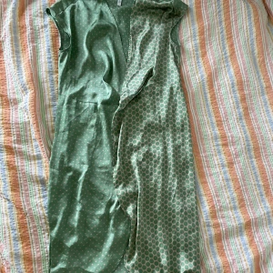 Grön prickig klänning från MNG - En grön klänning från MNG med vita prickar. Klänningen har en omlott-design och är ärmlös. Materialet ser ut att vara satin, vilket ger en glansig yta.