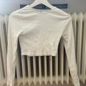 Vit långärmad - Långärmad kort topp från hm i ribbat material. Storlek S