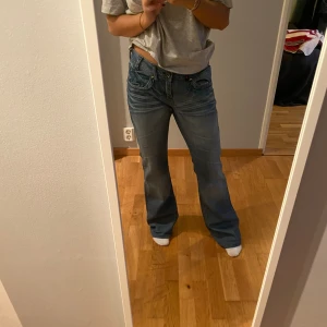 lågmidjade jeans - Lågmidjade jeans där sömmen där nere är uppsprättad. Innerbenslängden är 78cm och midjemåttet 38.