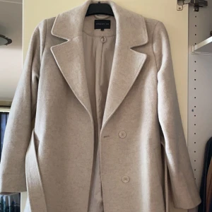 Kappa - Vit vinter/höst kappa, strl 34, 100% ull. Skön att ha både höst och vinter🤍 Ända defekten är 3 små fläckar på insidan av kappan men är absolut inget som syns, har ej försökt få bort dem men tror inte det skulle vara några problem🤍 