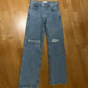 Medelmidjade ljusblåa baggy jeans i storlek 36 från Mango. Köpte i vintras men säljer pga köp i fel storlek. Den är i nyskick förutom att hålet på ena benet har gått upp lite. Priset kan diskuteras. 