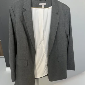 Grå kavaj - Super snygg kavaj från H&M, den har inte kommit till använd och är så gott som ny😌