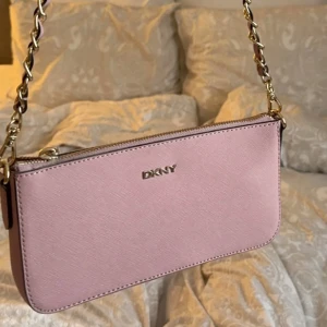 DKNY väska  - Väska från DKNY, måtten är 12x23. Följer med 2 band som båda är avtagbara! Fint skick💗