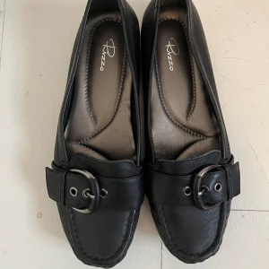 Loafers - Svarta loafers med coolt spänne på, köpta second hand 