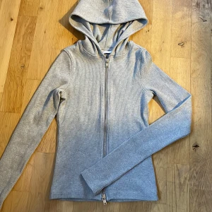 Fin hoodie tröja - Jättefin hoodie. Sitter tajt. Jättefin men jag har växt ur den. Bomull och elastan. Dragkedja både uppe och nere så att man kan öppna från vadå hållen.