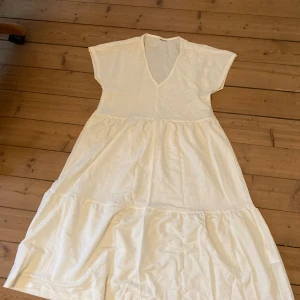 Vit lång volang klänning - Köpt second hand, inga tydliga defekter. Hela klänningen är 91 cm och den är 38 cm över bysten. Kontakta mig privat vid frågor eller intresse 