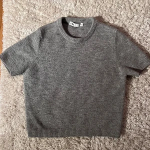 Stickad grå t-shirt  - Säljer denna fina stickade tröja pga att den var för liten för mig. Knappt använd. Köpt för 329 och säljer den för 250🩶