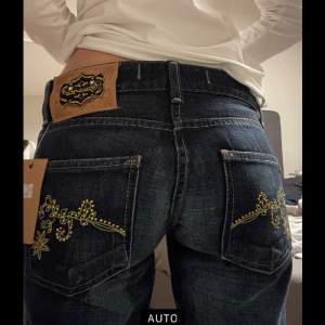 lågmidjade raka jeans med blommor och stenar på fickorna, felfri 36cm midja 83cm innerbenslängd ❤️säljer andra jeans, kolla gärna❤️ 