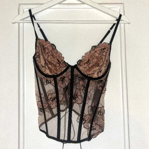 Broderad Victorias Secret-korsett - Vacker korsett i perfekt skick från Victorias Secret. Endast använd 1 gång och storlek 70C. Storleken kan justeras beroende på hur hårt man drar åt korsetten, och man behöver inte dra åt den varje gång då den har dolt blixtlås i sidan 💕Nypris 1700kr