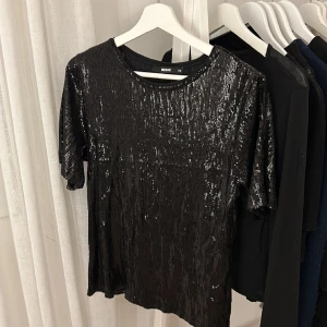 Glittrig fest topp - Jätte fin svart topp som passar bra till fest. Endast använd en gång💞 väldigt fin i ärmarna då dom är lite ”längre” som man kan se på sista bilden💞 ordinarie pris är 500kr❤️