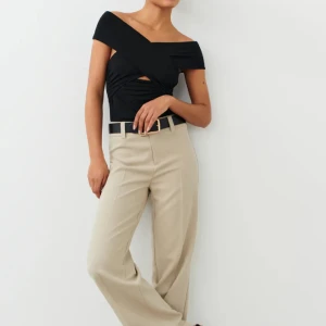 Soft Touch wrap top - Slutsåld svart topp från Gina Tricot. Lappen är avklippt men toppen har aldrig blivit använd. Storlek M Off Shoulder med crossover i bysten  
