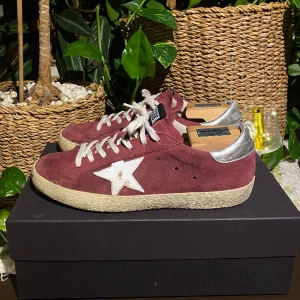 Golden Goose Superstar Ruby  - Hej! Säljer ett par populära Golden Goose sneakers i snygg och sällsynt vinröd colorway. Skorna är i bra skick och sparsamt använda,DM för bilder. Storlek 43 och True To Size. Inget OG. Nypris 5000kr. Pris kan diskuteras i DM. Hör av dig vid frågor. 