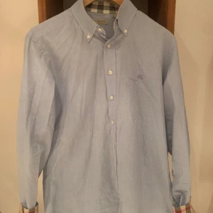 Burberry  - Burberry skjorta  Storlek M  Pris 799  Stilren ljusblå färg 