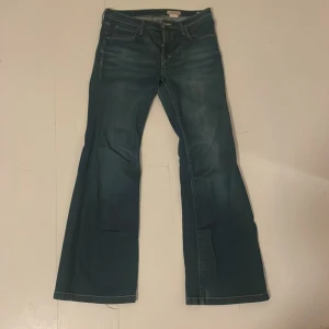 Lågmidjad Bootcut Jeans - Basic blåa lågmidjad bootcut jeans. Har tyvärr blivit för korta på mig. Litet hål vid hälen men kan lätt fixas.