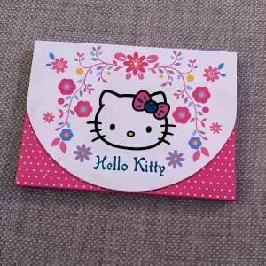 Hello Kitty block med spegel - Supergulligt block med Hello Kitty-motiv. Stängs med kardborre. Ej använt block. En hjärtformad spegel på insidan. 