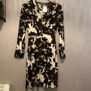 Klänning  - Elegant möntrad klänning från H&M i storlek xs. Aldrig använd och har etikett kvar