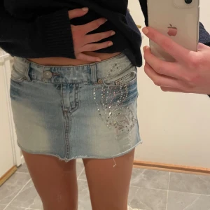 Jeanskjol - Jeanskjol med fjäril i paljetter, fram och baktill. Kort i modellen. Snygga detaljer. 