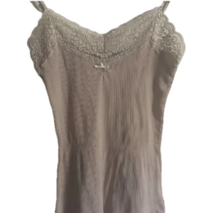 spetslinne - ett gulligt rosa linne med spetskant och rosett! fint skick förutom en pyttepytteliten missfärgning som knappt märks, men syns på sista bilden 💛