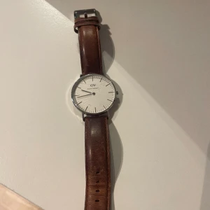 Klocka från Daniel Wellington  - Klocka från Daniel Wellington med brunt läderband. Uret har några repor men är i övrigt i bra skick!