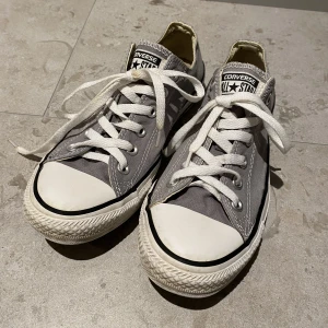 Grå converse - Gråa låga converse i storlek 39, använda men syns inte väl förutom sliten logga vid hälarna. Säljer då dom är för små för mig :)