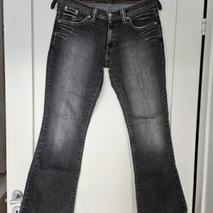 Levis Jeans  - Svart/gråa Levi’s Jeans i mycket bra skick! W 31, L 30, så passar M. Utsvängda och lågmidjade!! Tryck gärna på köp nu 