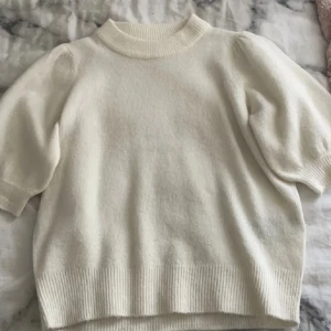 Vit stickad tröja från ONLY - En vit stickad tröja från ONLY med korta puffärmar och ribbstickade muddar vid ärmslut, hals och nederkant. Tröjan har en rund halsringning och är tillverkad i ett mjukt och bekvämt material. Storleken är M men skulle säga mer en xs💓