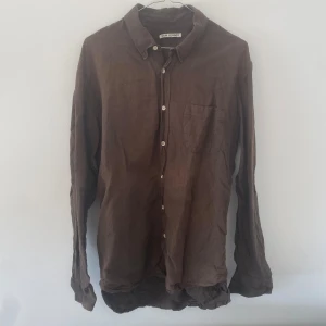 Our Legacy classic shirt - Säljer en brun classic shirt från Our Legacy i size 50/L! Som namnet säger, en klassisk skjorta med regular fit - helt enkelt en perfekt basskjorta för alla tillfällen. Denna har en bomulls- och linnemix.