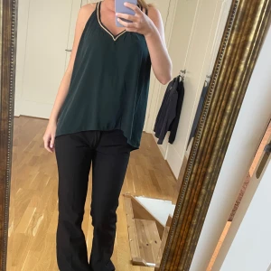 Blus - Snygg mörkgrön blus med gulddetaljer. V-ringad och typ som kors i ryggen där tröjan går ihop😊kan självklart diskutera pris