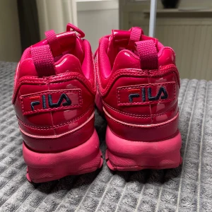 Fila skor röda  - Säljer dessa fina med cool röd färg!! Har använt de max 2 gånger köpte när jag var utomlands men sen när jag kom hem såg att de inte var riktigt min grej men de är ganska fina annars lite unika med färgen på skorna. helt nya 