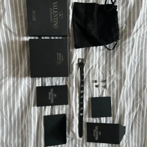 Valentino armband - Äkta valentino armband i svart. Som man kan se på bilderna finns tecken på användning speciellt ”baksidan” av armbandet. Taggarna i bra skick men tecken på användning finns absolut på topparna. Org förpck, dustbag m.m följer med.Tyvärr ej kvitto!