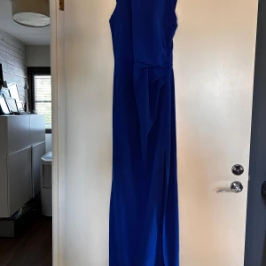 Blå långklänning  - Jag säljer denna super fina långkläning med slits från bubbleroom. Den är använd 1 gång och ser ut som ny. Säljer denna då den inte kommer till användning.