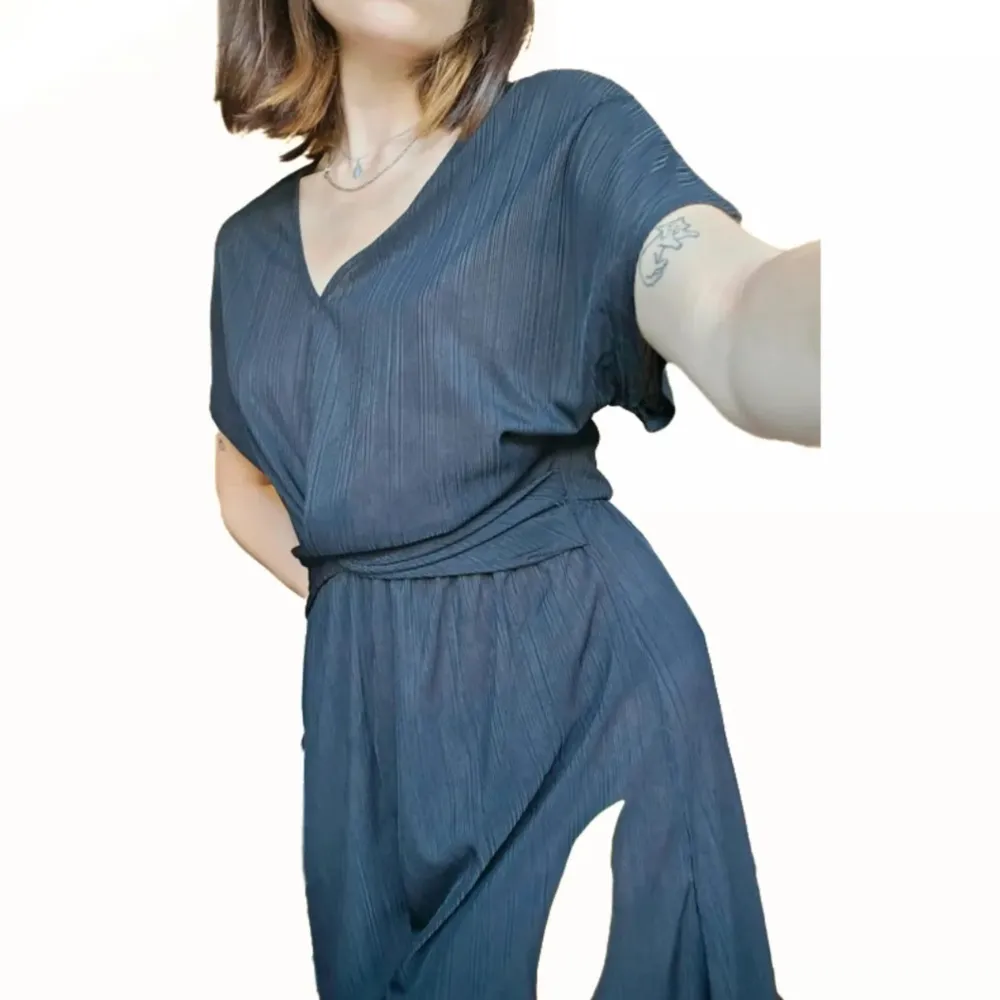 En svart jumpsuit med korta ben och ärmar. Väldigt luftig och passar perfekt varma sommardagar. Knapp finns i nacken. Använd två gånger och i bra skick. Märke: QED London Storlek: S. Mekot.