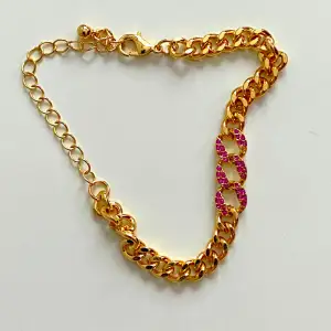 Vackert guldfärgat armband med rosa rhinestones  Gott skick  23 cm lång  Okänd metall 