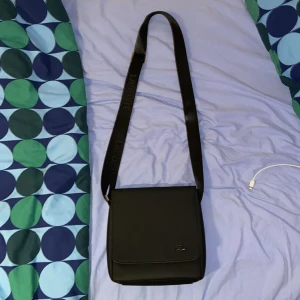 Lacoste axelväska - Hej! Jag säljer en helt ny Lacoste axelväska. Den har jag aldrig använt ute. Vid fler frågor eller funderingar så är det bara att höra av sig👍